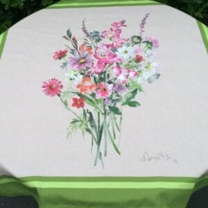 A white table cloth bordered in green with flowers in the center