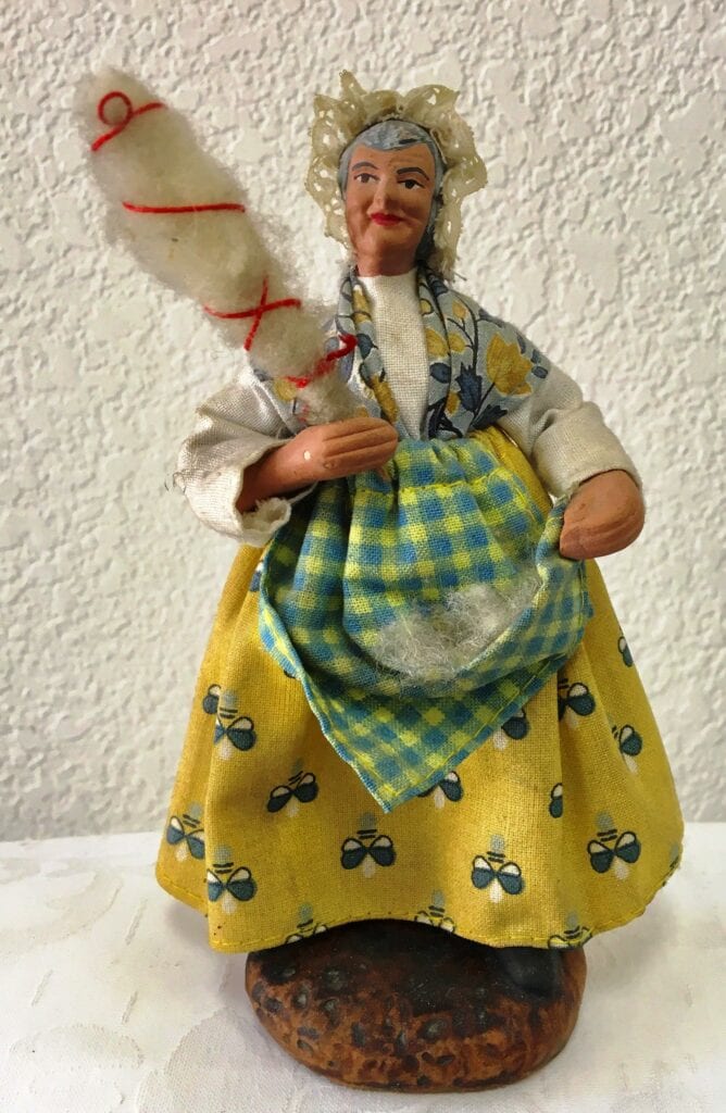 A small statue of an old woman with a duster