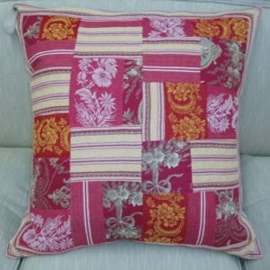 A red small pillow with floral patches
