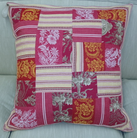 A red small pillow with floral patches