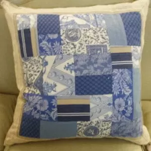 A small blue pillow with floral patches