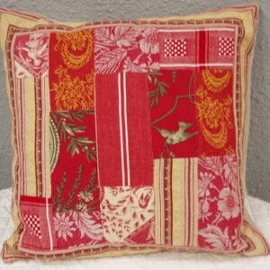 A red and pink pillow case with floral patches