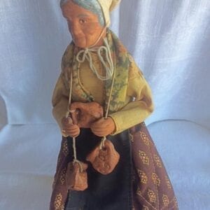 A small statue of an old woman with hanging carvings