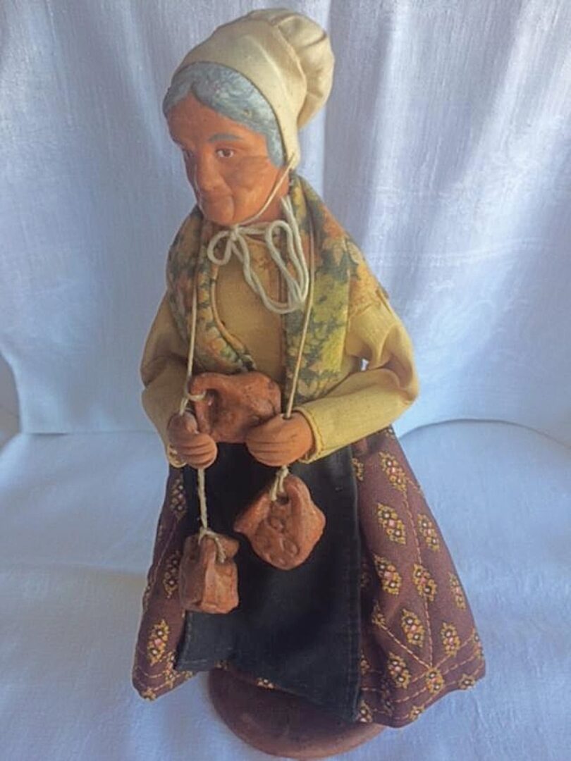 A small statue of an old woman with hanging carvings