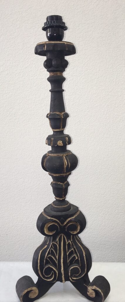 A gilded black lamp base sconce