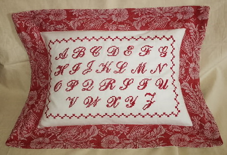 A red pillow case with the alphabet design