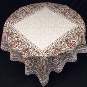 A white table cloth with red patterns around the edges