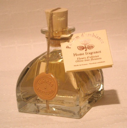 A bottle of yellow perfume with olive tree flowers scent