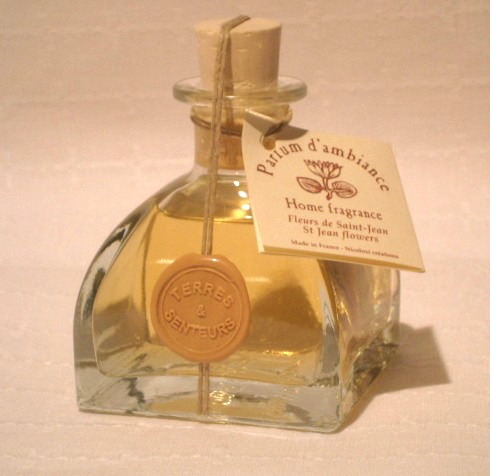 A bottle of yellow perfume with St. Jean flowers scent