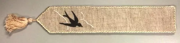 A black bird embroidery on a piece of linen
