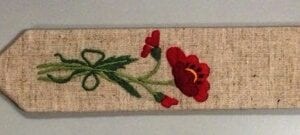 A red flower embroidery on a piece of linen