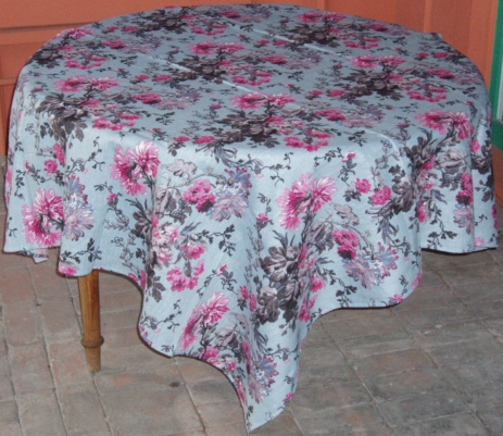 A linen table cloth with pink floral designs