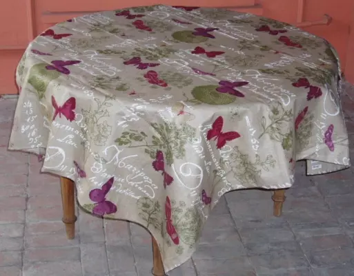 A cream colored linen table cloth with butterfly patterns