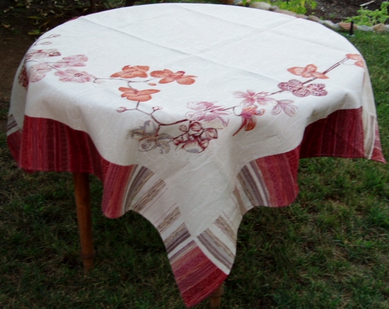 A white table cloth with floral designs at the sides