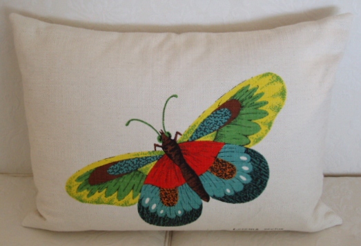 A white pillow case with a butterfly with three colors