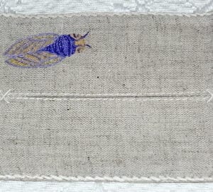 A blue bug embroidered into the cloth