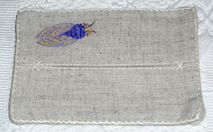 A blue bug embroidered into the cloth
