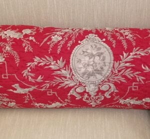 A red long pillow case with vine designs