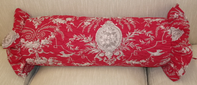 A red long pillow case with vine designs