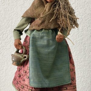 A small statue of an old woman holding a tea pot and sticks