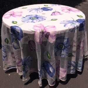 A white table cloth with purple and blue flowers