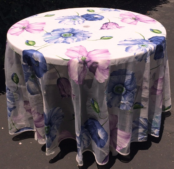 A white table cloth with purple and blue flowers