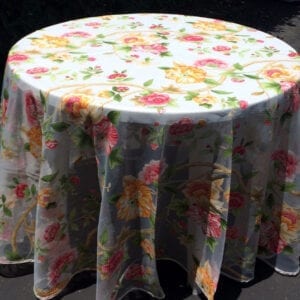 A white table cloth with orange and pink flowers