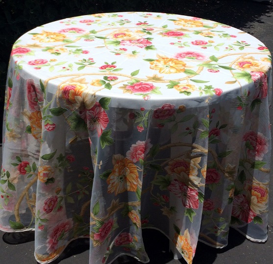 A white table cloth with orange and pink flowers