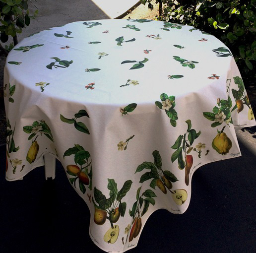 A white table cloth with leaves and fruits as designs
