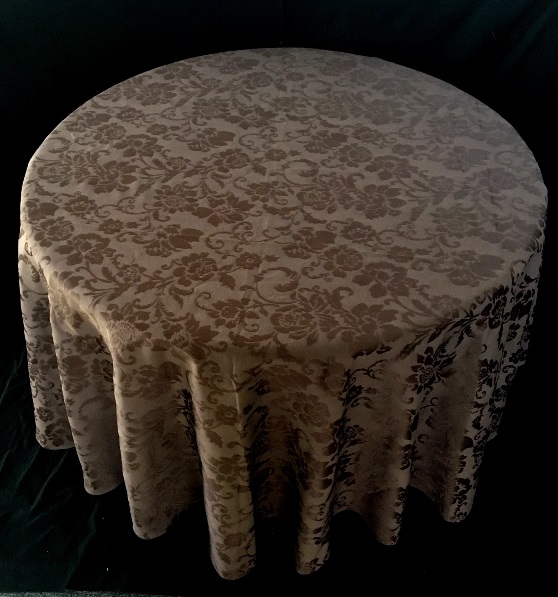 A light brown table cloth with dark patterns