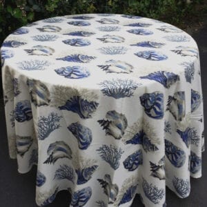 A white table cloth with blue shells and corals