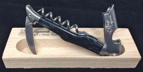 A pocket knife with a cork screw on a box