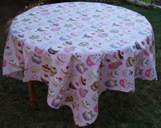 A white table cloth with cupcake patterns