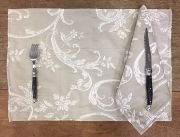 A grey placemat with white vine designs