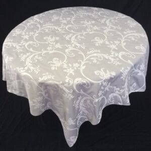 A white table cloth with bright vine and floral patterns