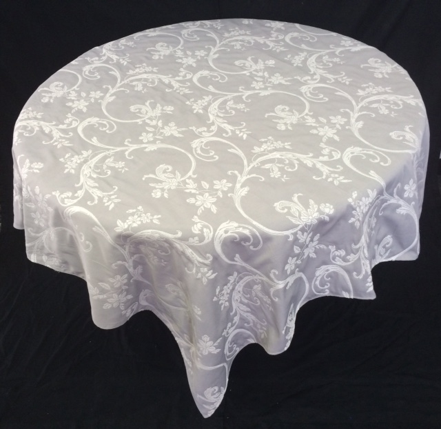 A white table cloth with bright vine and floral patterns