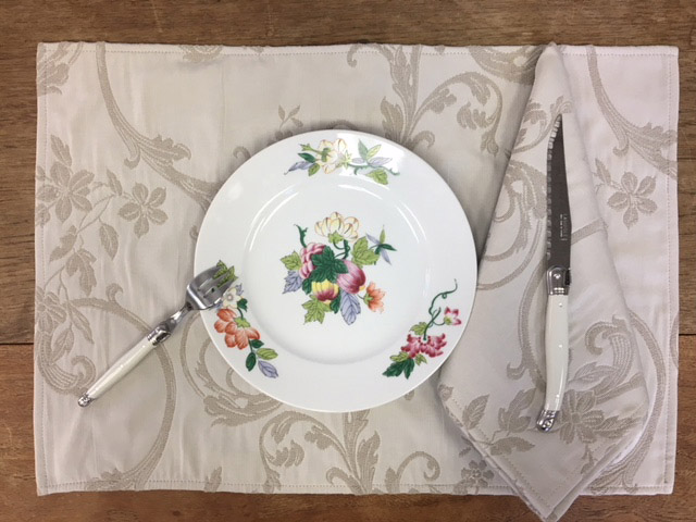 A grey placemat with a plate and utensils
