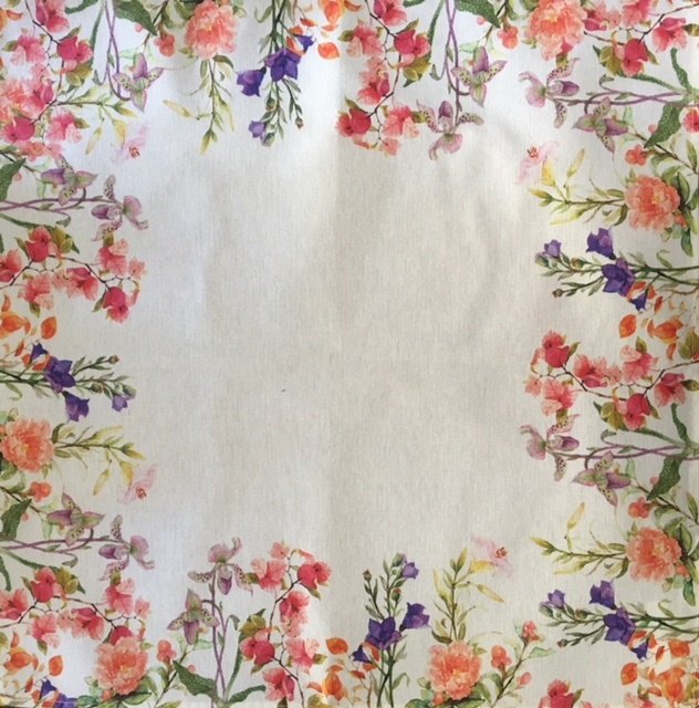 A white napkin with floral designs at the edges and corners