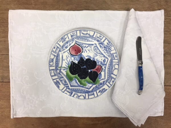 A white placemat with a blue plate