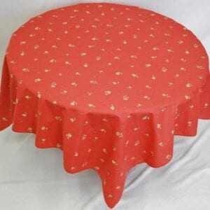 A pale red table cloth with small yellow flower patterns