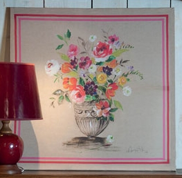 A pink artwork with a vase of flower in the center