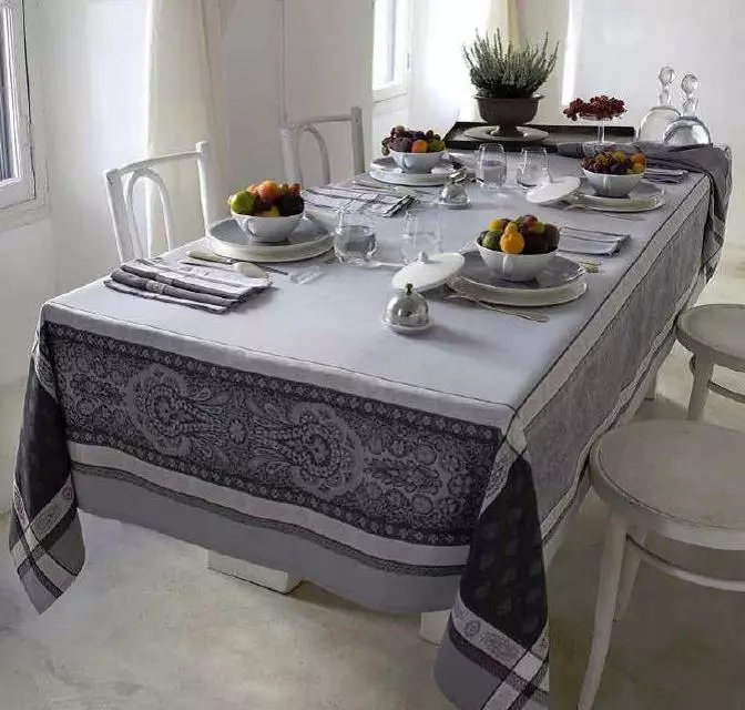 A white table cloth with dark grey patterns